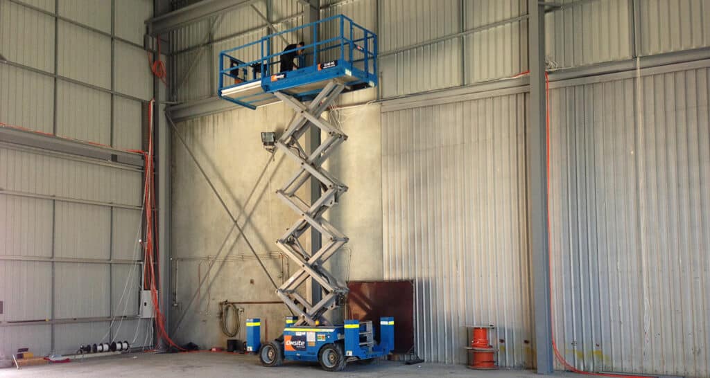New construction electrician performing electrical services in a scissor lift