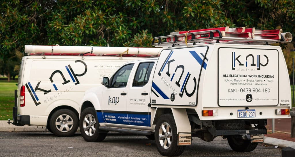 KNP electrical service vehicles in a parking lot next to the river in Perth